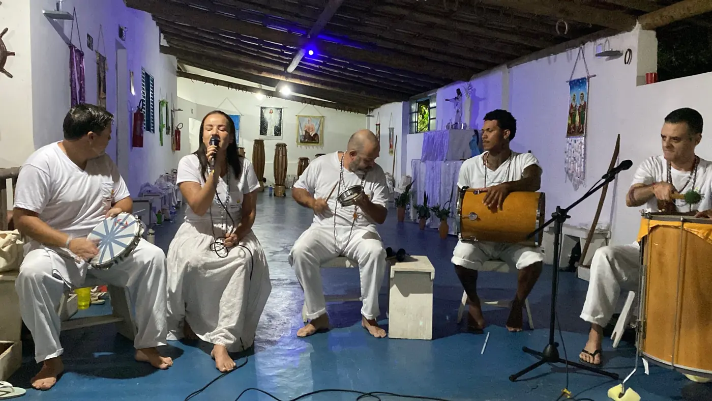 A cantora do Encantuá ao microfone, acompanhada pelos percussionistas